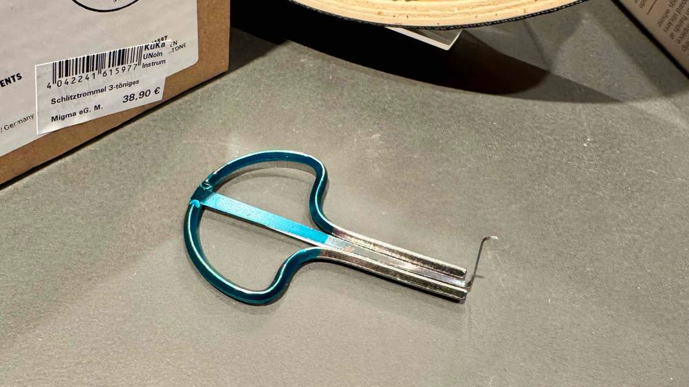 Eine getestete Maultrommel horizontal auf einer grauen Fläche.