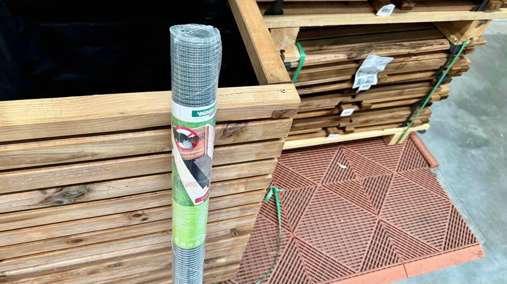 Maulwurfgitter-Test: Nahaufnahme der Rolle mit Label an einer Holzbox lehnend.