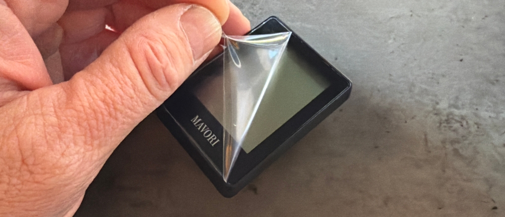 Eine Hand entfernt eine Folie vom Display des Mavori E0345