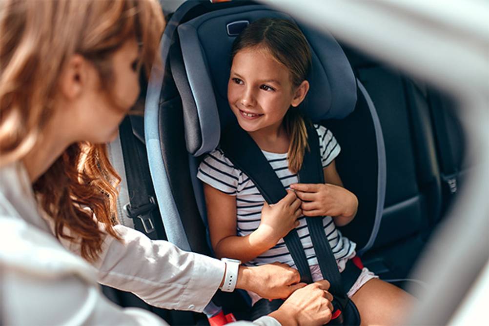 Maxi-Cosi-Kindersitz 9 -36 kg im Test: Eine Mutter überprüft den 5-Punkt-Gurt der Tochter.