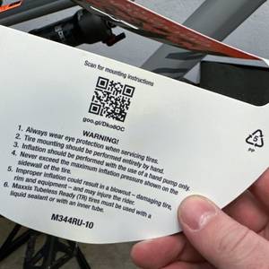 Die Rückseite der Verpackung des Maxxis Cubierta zeigt Warnhinweise und QR-Code. Hinweise zur Montage sind aufgelistet.