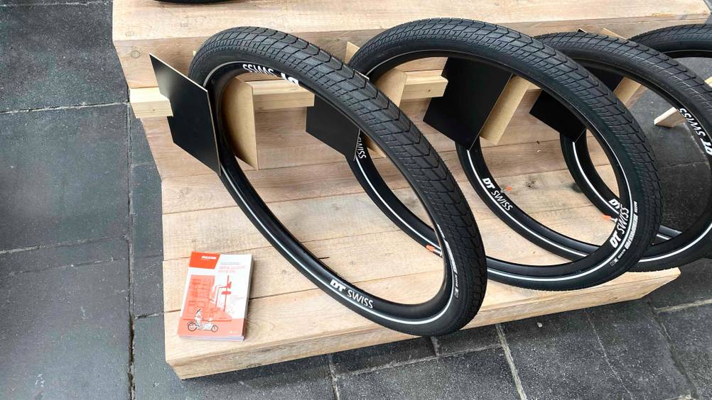 Im Test: Mehrere E-Bike-Reifen in einem Holzständer nebeneinander.