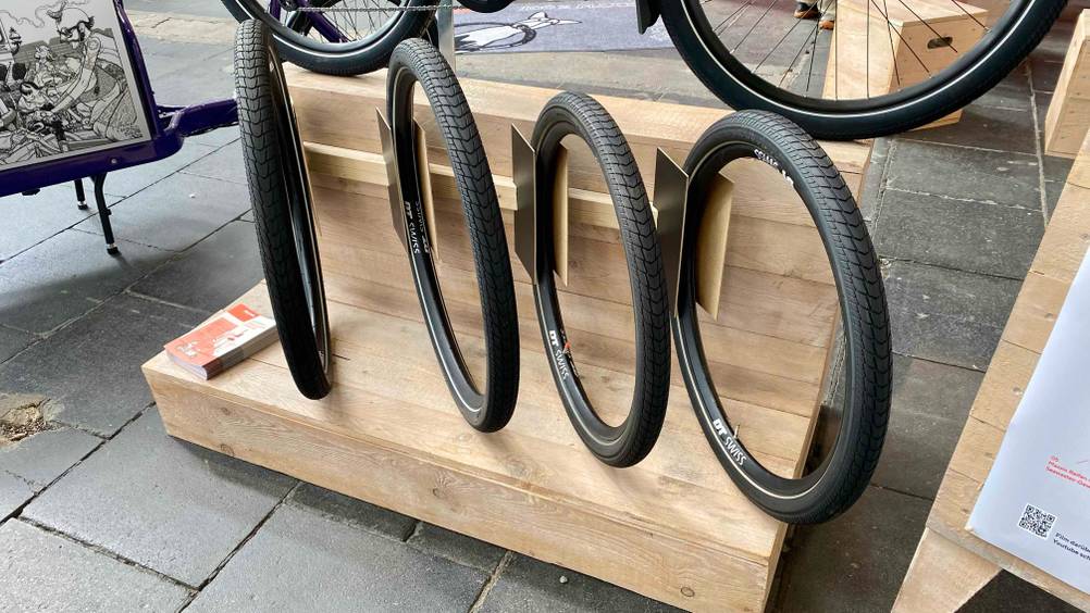 Mehrere unterschiedliche Größen des E-Bike-Reifens im Test auf einem Holzständer.