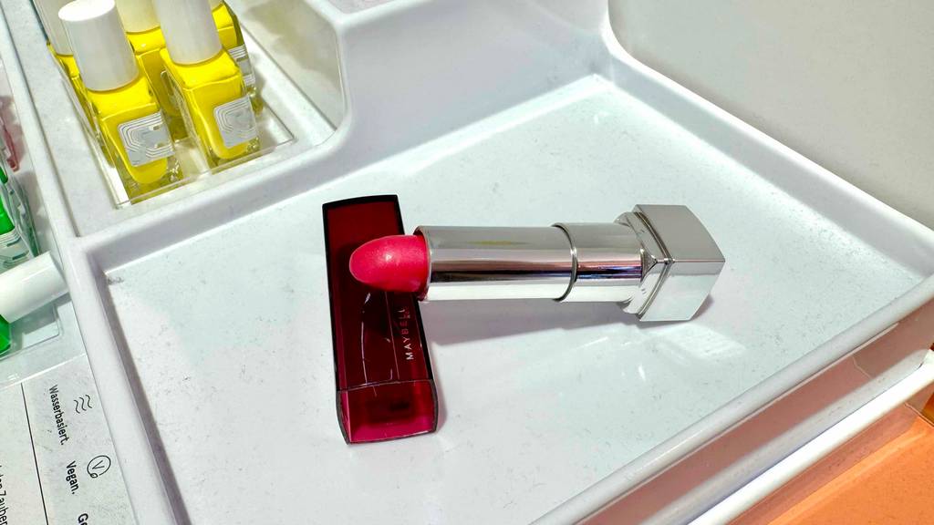 Ein geöffneter Maybelline Lippenstift liegt getestet quer auf der Kappe.