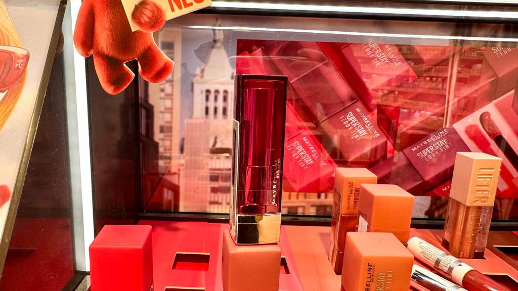 Maybelline Lippenstift-Test: Ein Stift steht zum testen neben anderen Kosmetikprodukten.