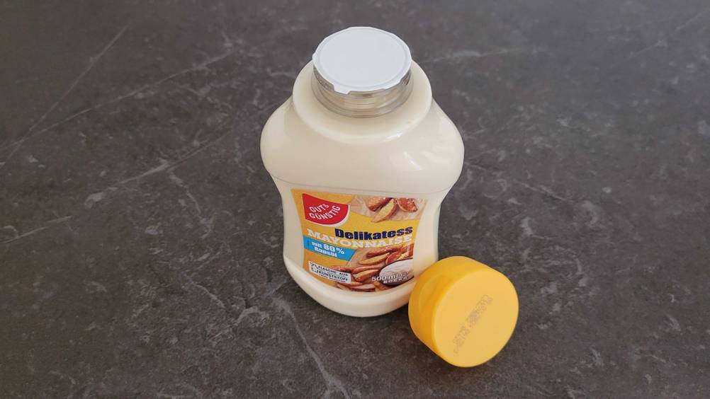 Eine Flasche Mayonnaise im Test mit Frischesiegel am Verschluss, die Kappe liegt daneben.