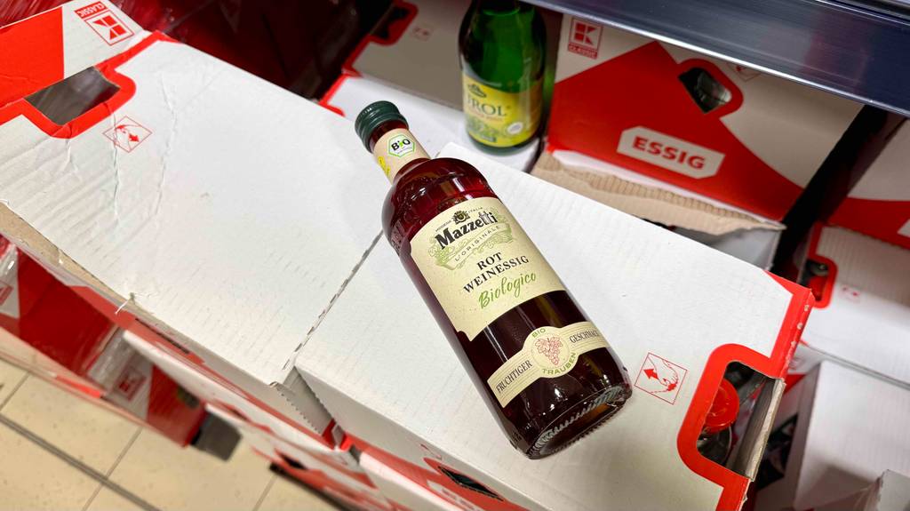 Rotweinessig-Test: Eine Flasche liegt schräg auf einem Karton.