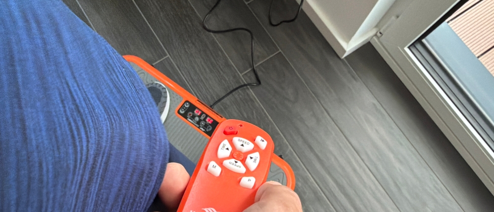 Eine Hand bedient die Fernbedienung der Mediashop Vibro Shaper ‎M12442.