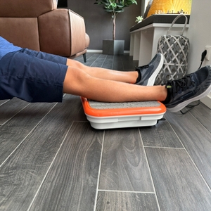 Zwei Beine liegen auf der Mediashop Vibro Shaper ‎M12442.