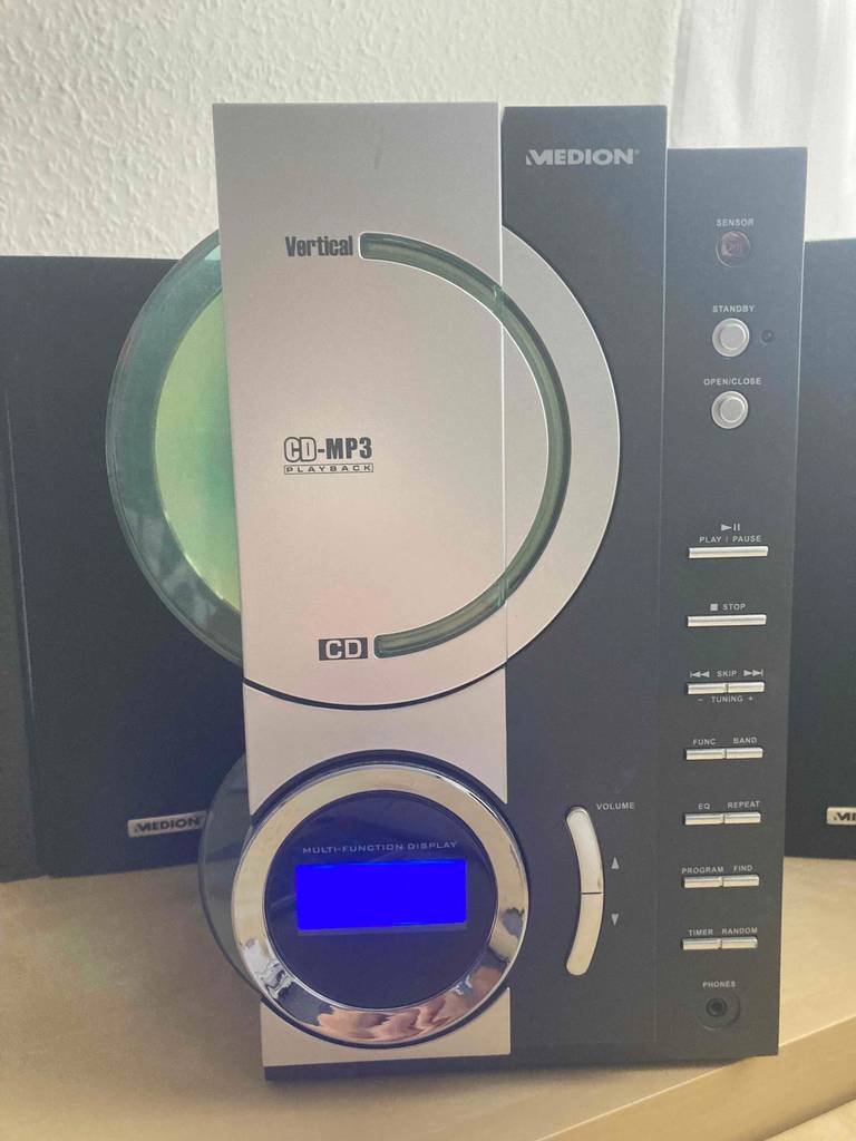 Nahaufnahme von vorn eines Medion CD-Players mit Kassettendeck im Test, mit Fokus auf das blau beleuchtete Display und den integrierten CD-Player.