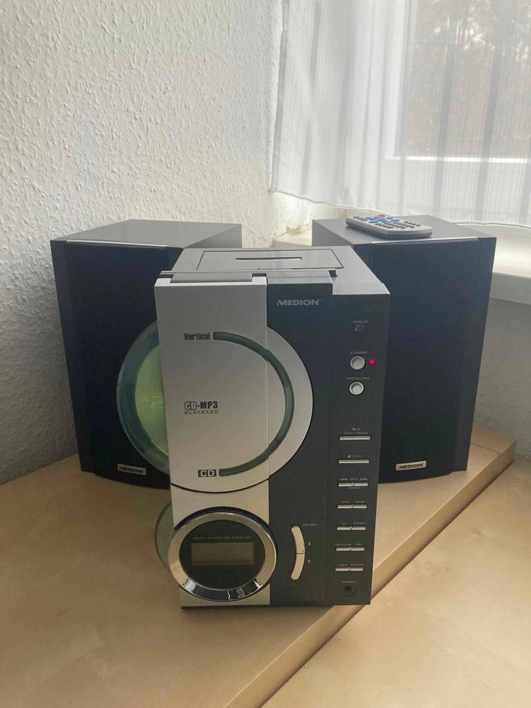 Gesamtansicht von einem grauen, getesteten CD-Player mit Kassettendeck inklusive zweier Boxen der Marke Medion.