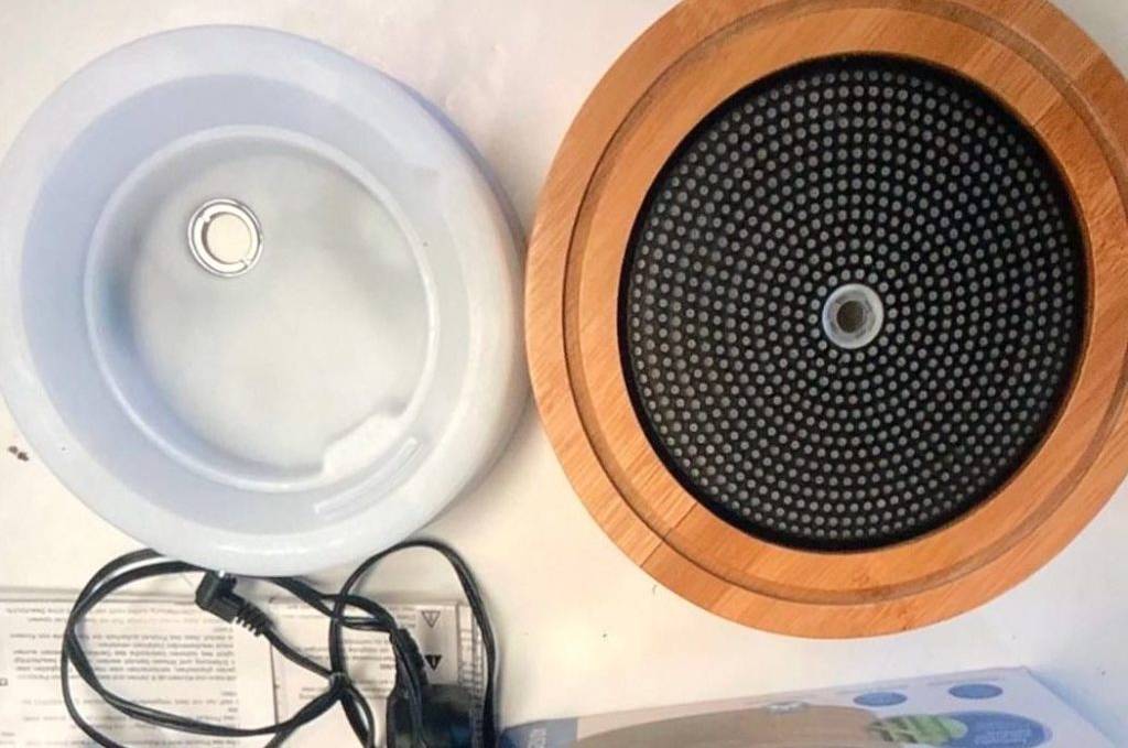 Diffuser im Test, ein Kunststoff-Holz-Modell von Medisana liegt ausgepackt neben seiner Originalverpackung, dem Adapter und der Gebrauchsanleitung.