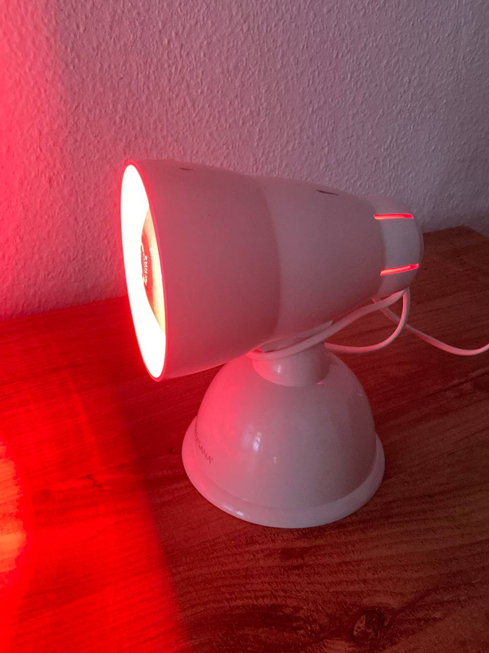 Im Test: Eine Rotlichtlampe leuchtet im Dunkeln.