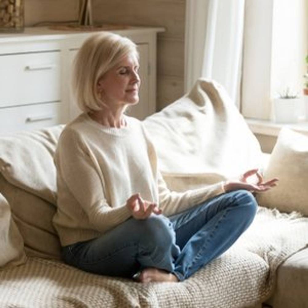 frau meditiert auf couch