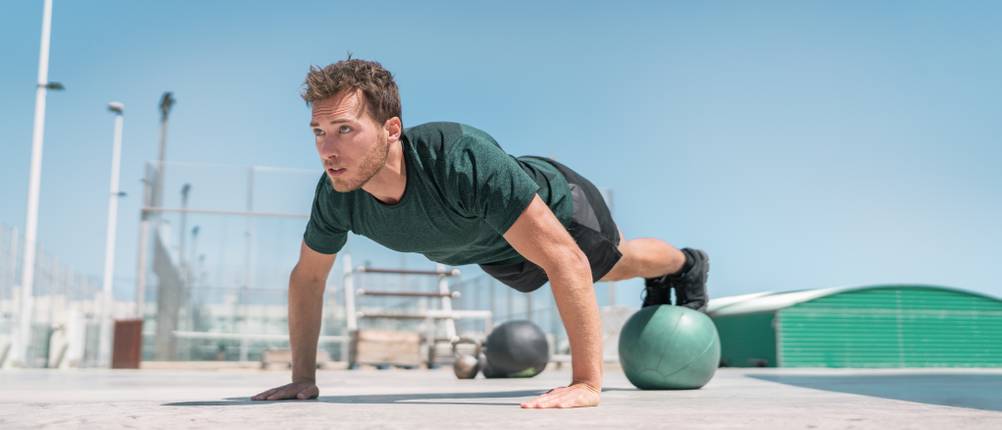 Medizinball im Test: Ein Mann trainiert mit einem Medizinball.