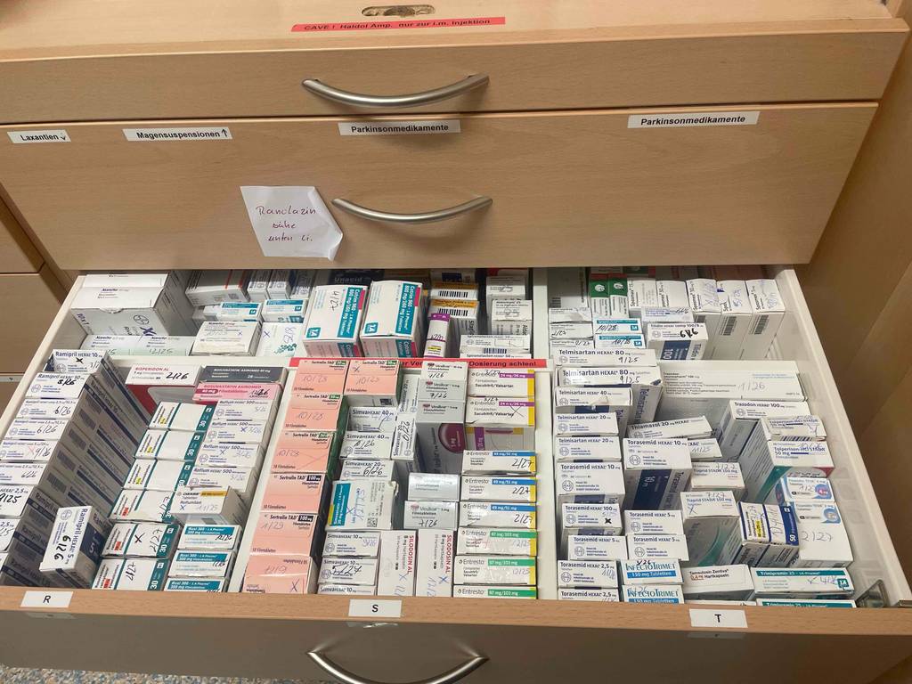 Medizinschrank-Test: Blick von oben auf eine geöffnete Schublade, die mit Medikamenten gefüllt ist.