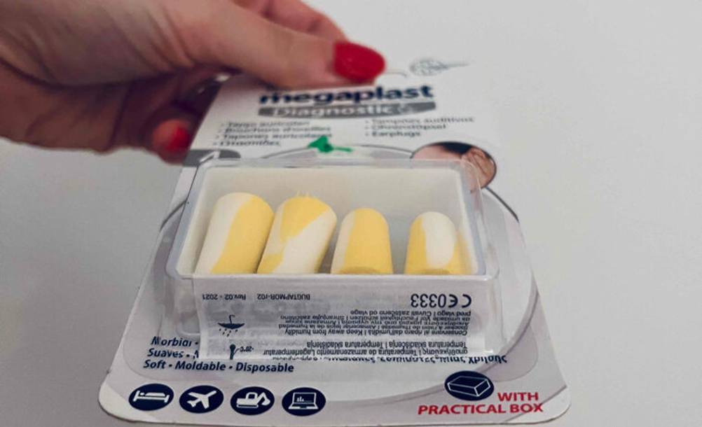 Eine Damenhand hält eine Verpackung vielseitiger Ohrstöpsel im Test, inklusive Aufbewahrungsbox.