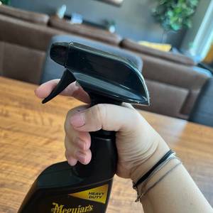 Eine Hand hält den Meguiar's Polsterreiniger ME G9416 fest.