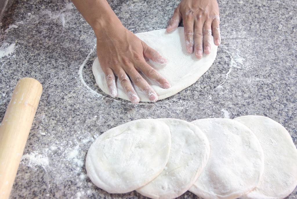 Mehl-00-Test: Eine Person formt mehrere Pizzateige. 