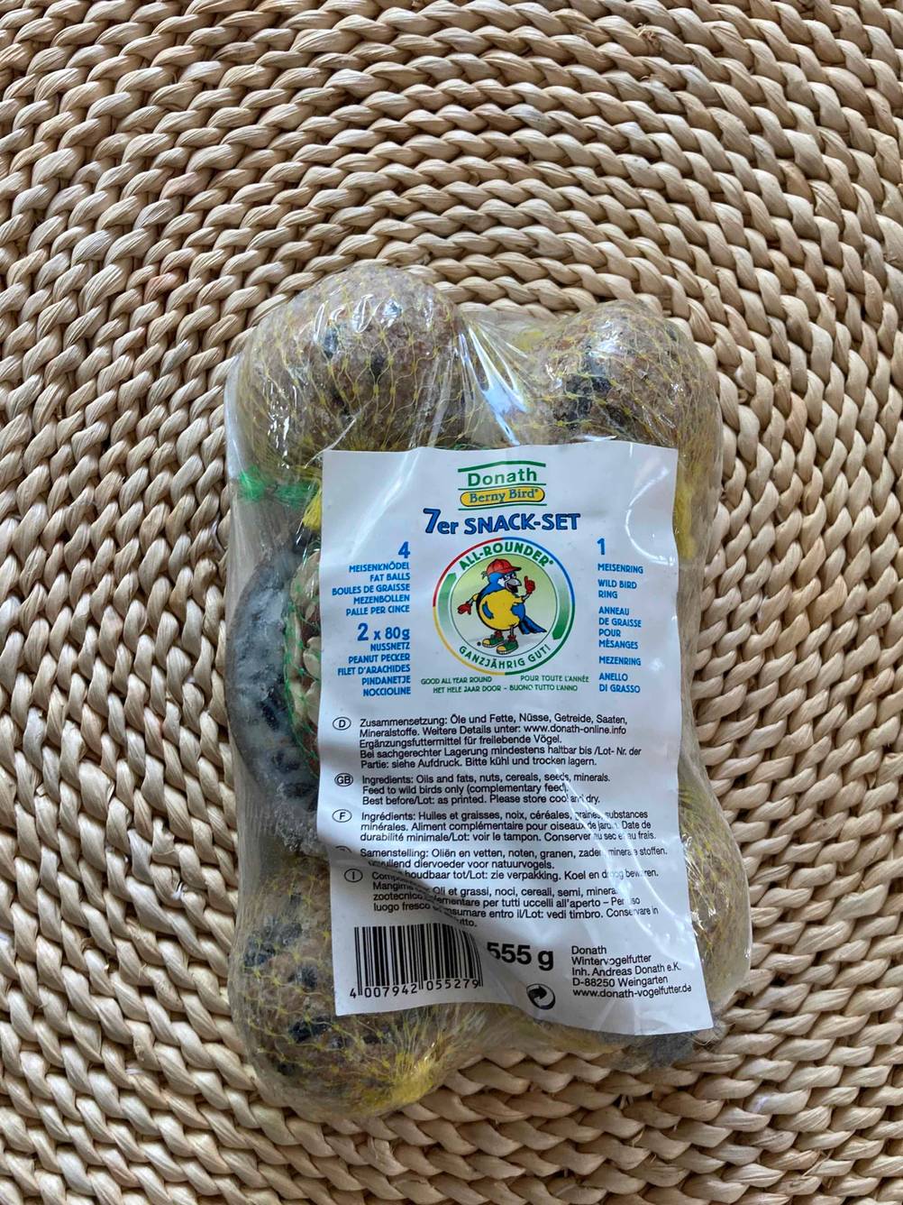 Eine Packung der getesteten Meisenknödel von vorne mit Label auf einer Korbfläche.
