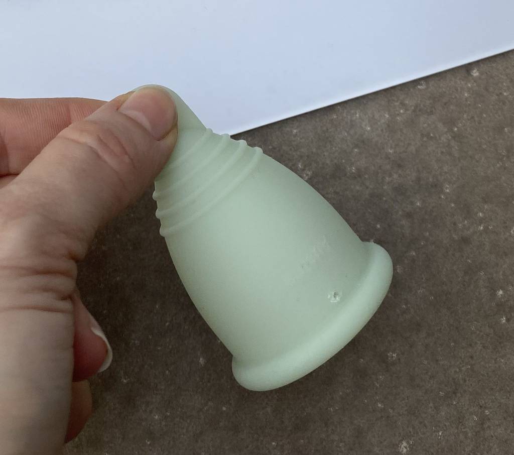 Menstruationstasse im Test: Hand hält Periodencup