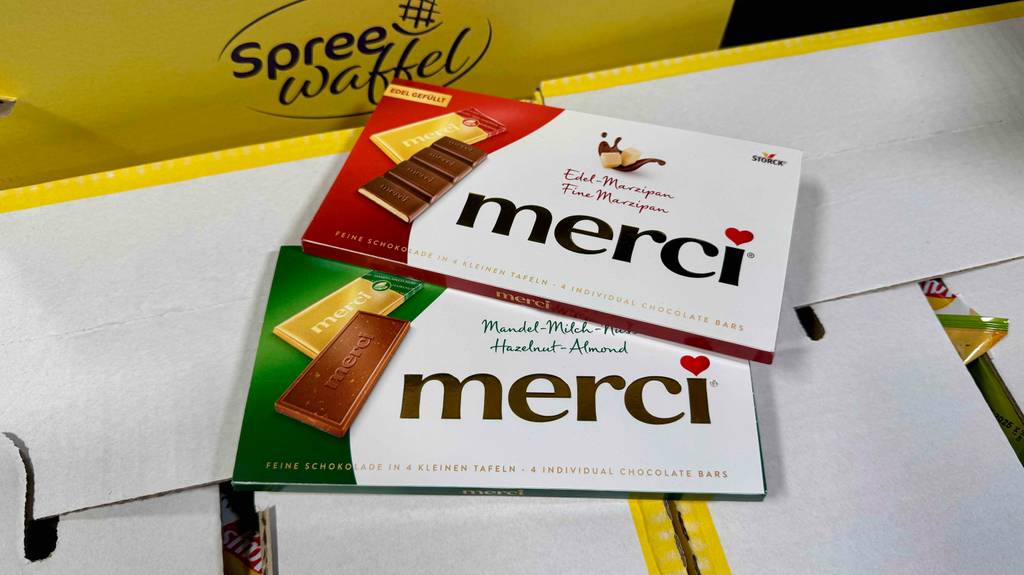 Zwei Tafeln Merci-Schokolade liegen zum Testen auf einem Karton.