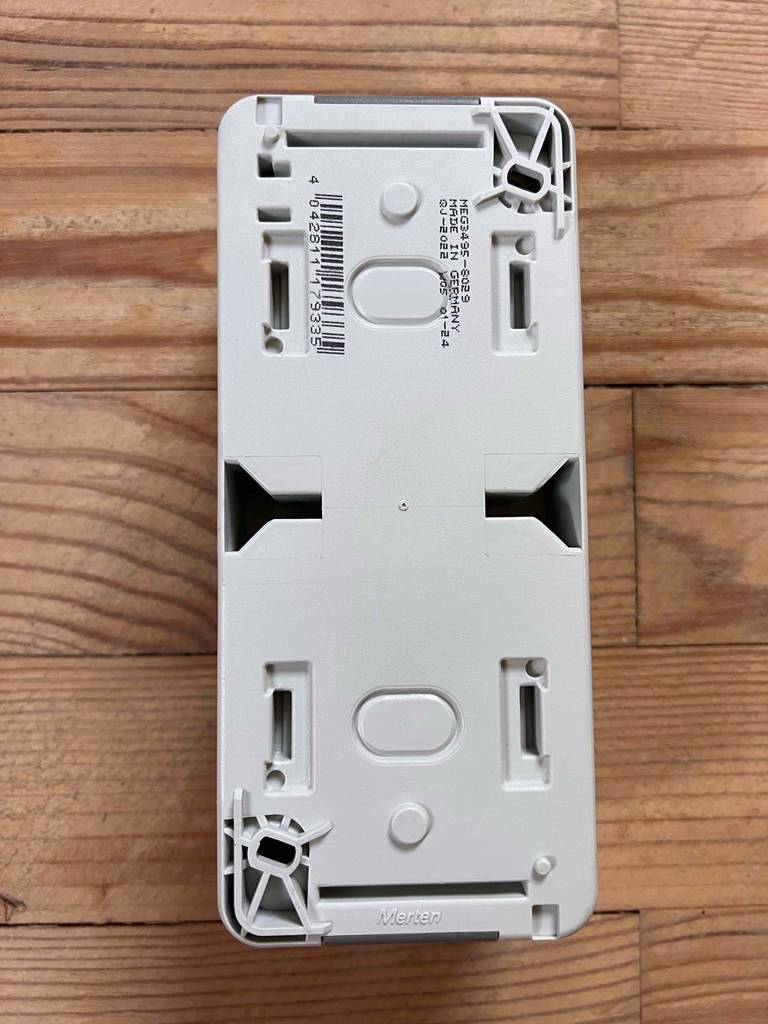 Aufputz-Steckdose getestet: Ein Modell mit der Rückseite nach oben auf einem Holztisch.