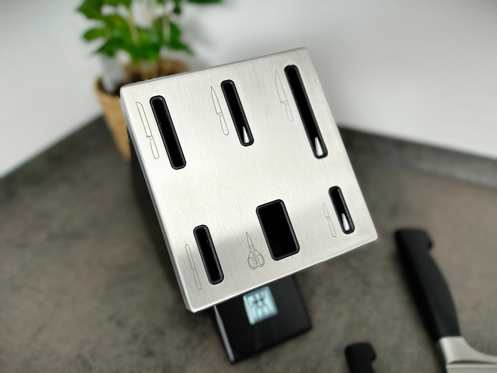 Die Oberseite des Messerblocks zeigt die Edelstahlplatte mit Symbolen und Einschüben. Die Schleifmechanik ist nicht sichtbar, aber enthalten.