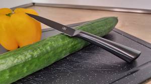 Messerset mit Gemüse auf einem Schneidebrett.
