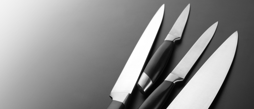 Vier Messer vor dunkelgrauem Hintergrund