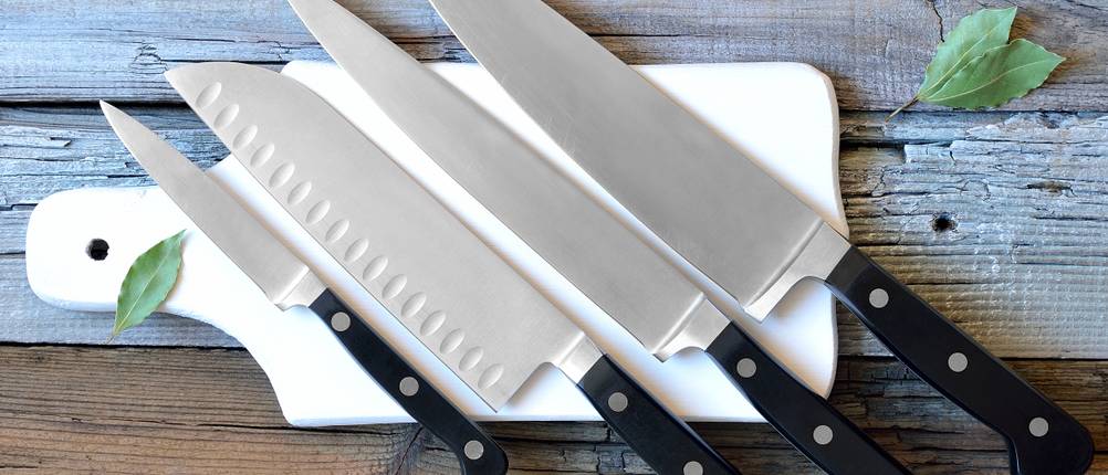 messerset zwilling test : Auf einem Keramik-Schneidebrett liegen verschiedenen Messer. 