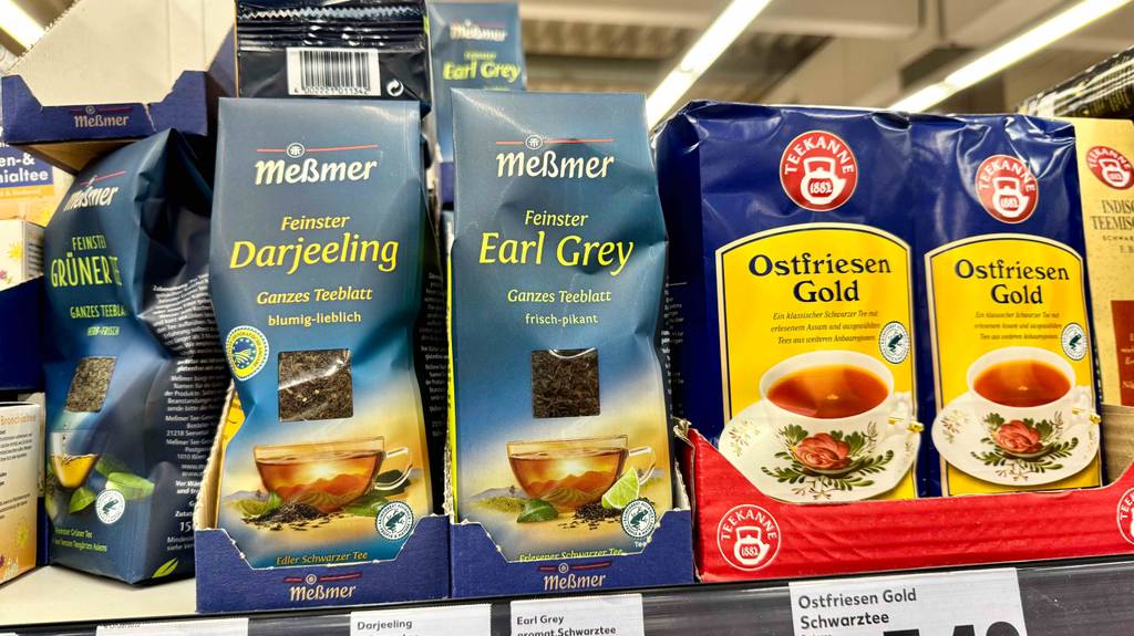 Mehrere Packungen mit Earl-Grey-Tee im Test stehen auf einem Verkaufsregal mit weiteren Teesorten.