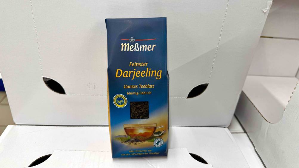 Meßmer-Tee im Test: Eine Packung auf und vor weißen Kartons.
