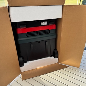 Der geöffnete Karton des Metabo ASR 25 L SC steht auf einem Tisch
