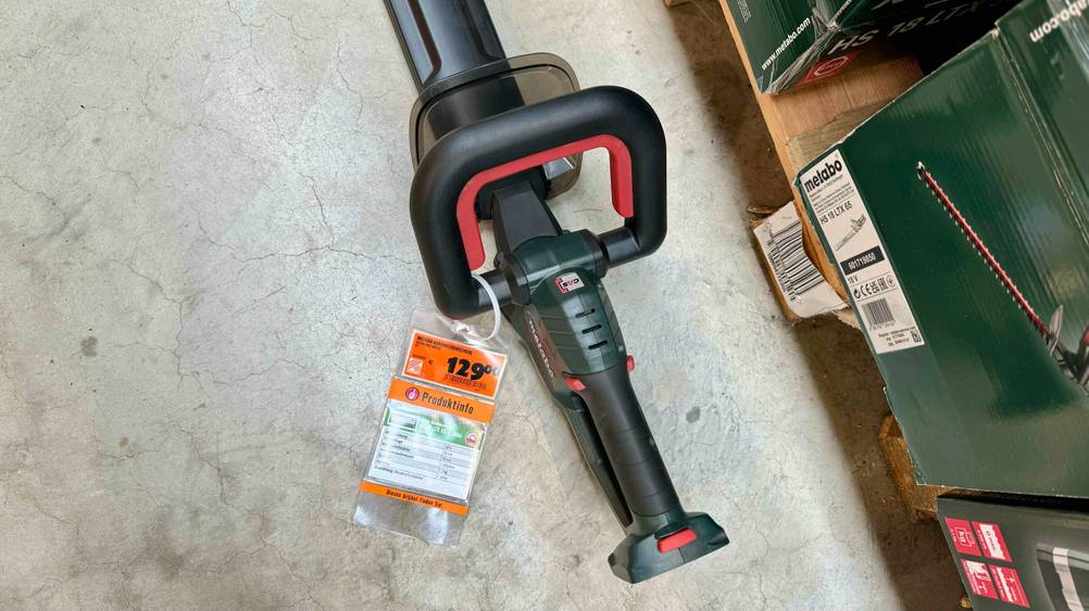 Nahaufnahme des Griffes einer getesteten Metabo-Heckenschere mit Preisangabe auf einem Betonboden.