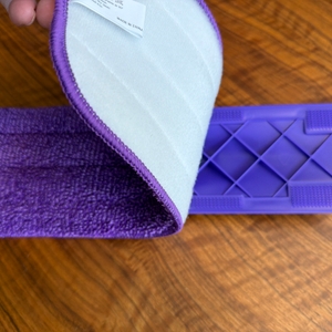 Eine Hand entfernt den Stoff von der Bodenplatte vom Mexerris-Sprühwischer.