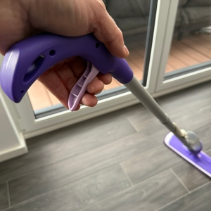 Eine Hand zieht an einem Hebel am Griff vom Mexerris-Sprühwischer.