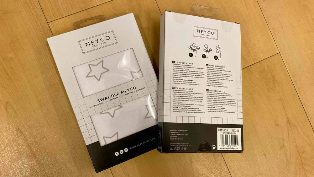 Pucksack im Test: Zwei verpackte Pucksäcke, einer von vorne und einer von hinten auf einer Holzfläche.