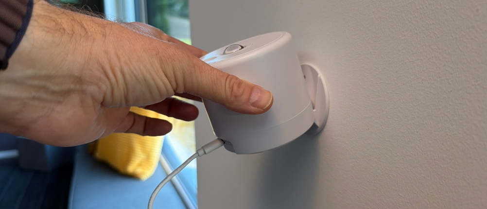 Eine Hand hält den Mhazdze-LED-Sternenhimmel-Projektor an eine Wand.