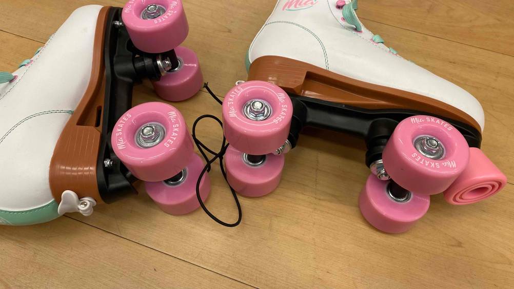 Getestete Rollschuhe für Kinder, verstellbar, liegen auf der Seite mit Blick auf die Unterseite.