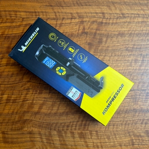 Der Karton des Michelin-Akku-Mini-Kompressors liegt auf einem Tisch