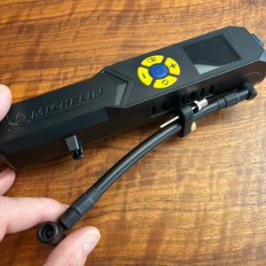 Eine Hand löst den Schlauch vom Michelin-Akku-Mini-Kompressor