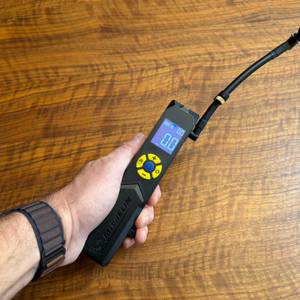 Eine Hand hält den Michelin-Akku-Mini-Kompressor fest