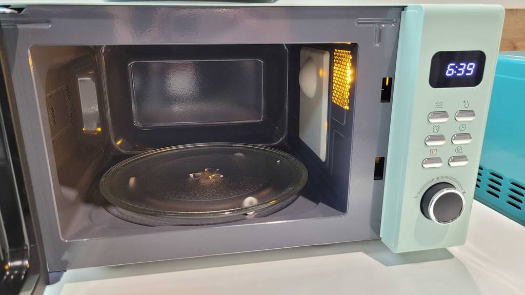 Im Test: Innenansicht mit Glasdrehteller einer geöffneten Retro Mikrowelle.
