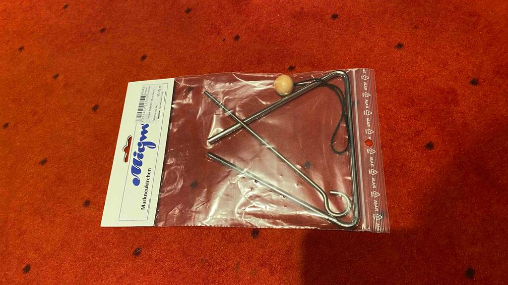 Triangel getestet: Triangel liegt in Verpackung auf roter Oberfläche.