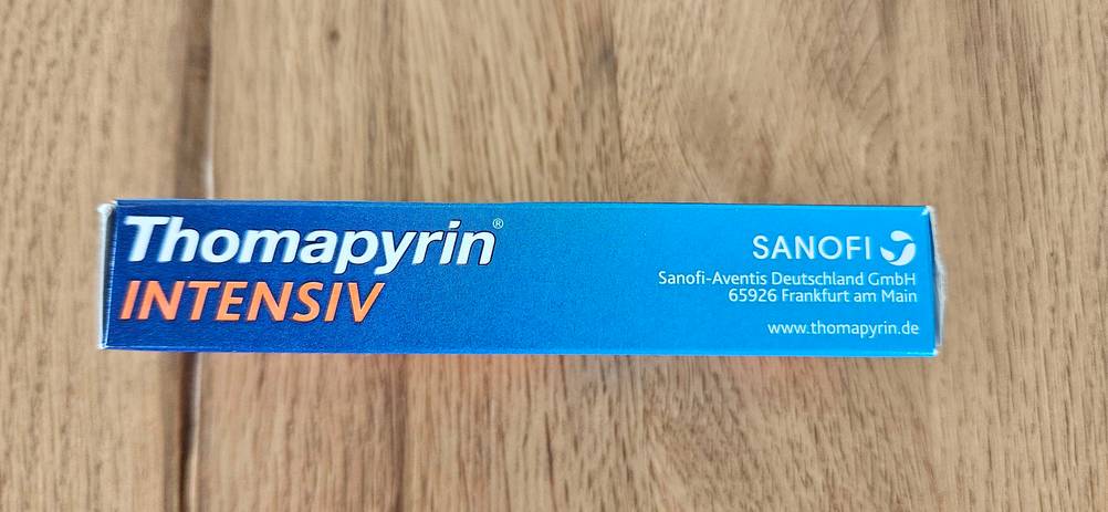 Seitenansicht einer Packung der getesteten Migräne-Tabletten auf einem Holztisch.
