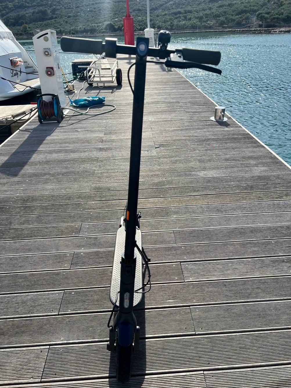 Getesteter Elektroroller inklusive Klingel von vorn auf einem Bootssteg.