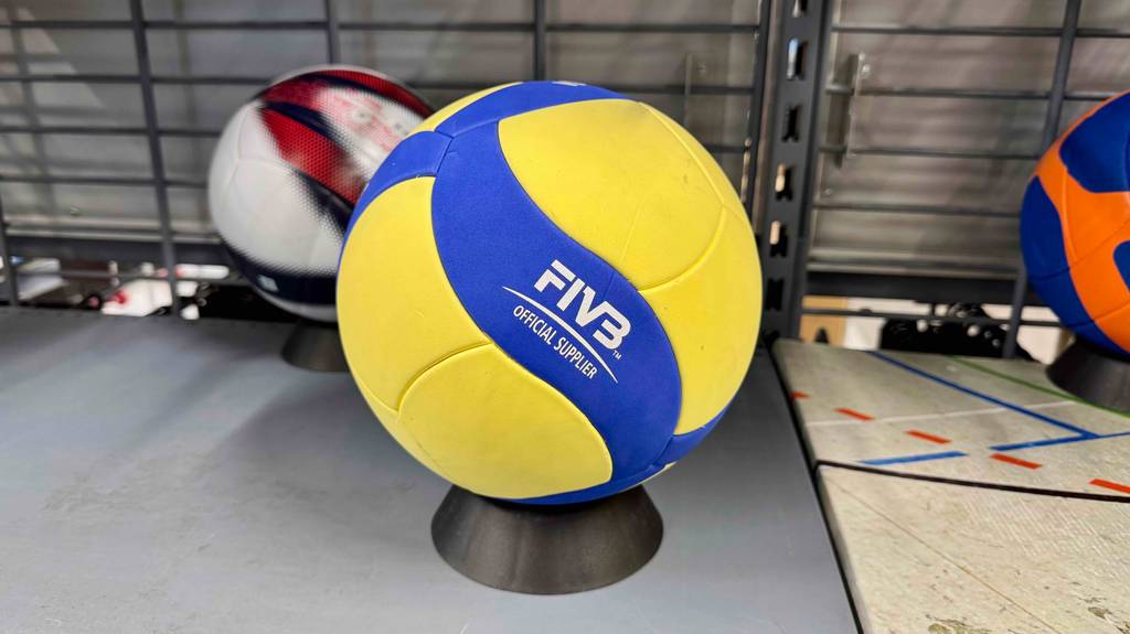 Ein Mikasa-Volleyball steht zum Testen auf einem Ballständer, im Hintergrund andere Bälle.