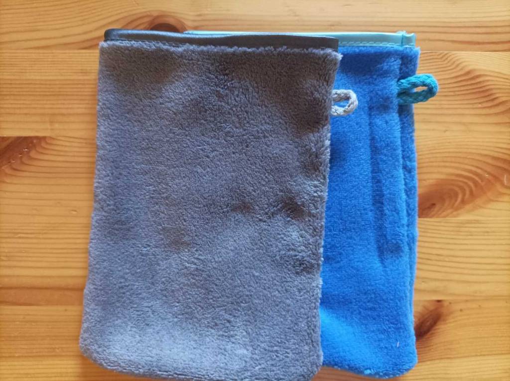 Ein blauer Mikrofaser-Waschlappen liegt zum testen unter einem grauen auf einer Holzfläche.