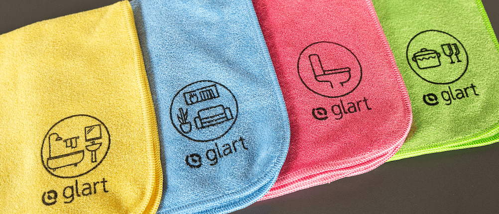 Mikrofasertuch-Test: Vier verschiedene Tücher einer Marke mit unterschiedlichen Logos liegen nebeneinander.